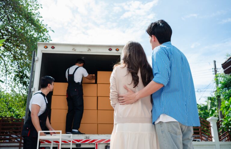 Asian Couple check while unloading boxes and furniture from a pickup truck