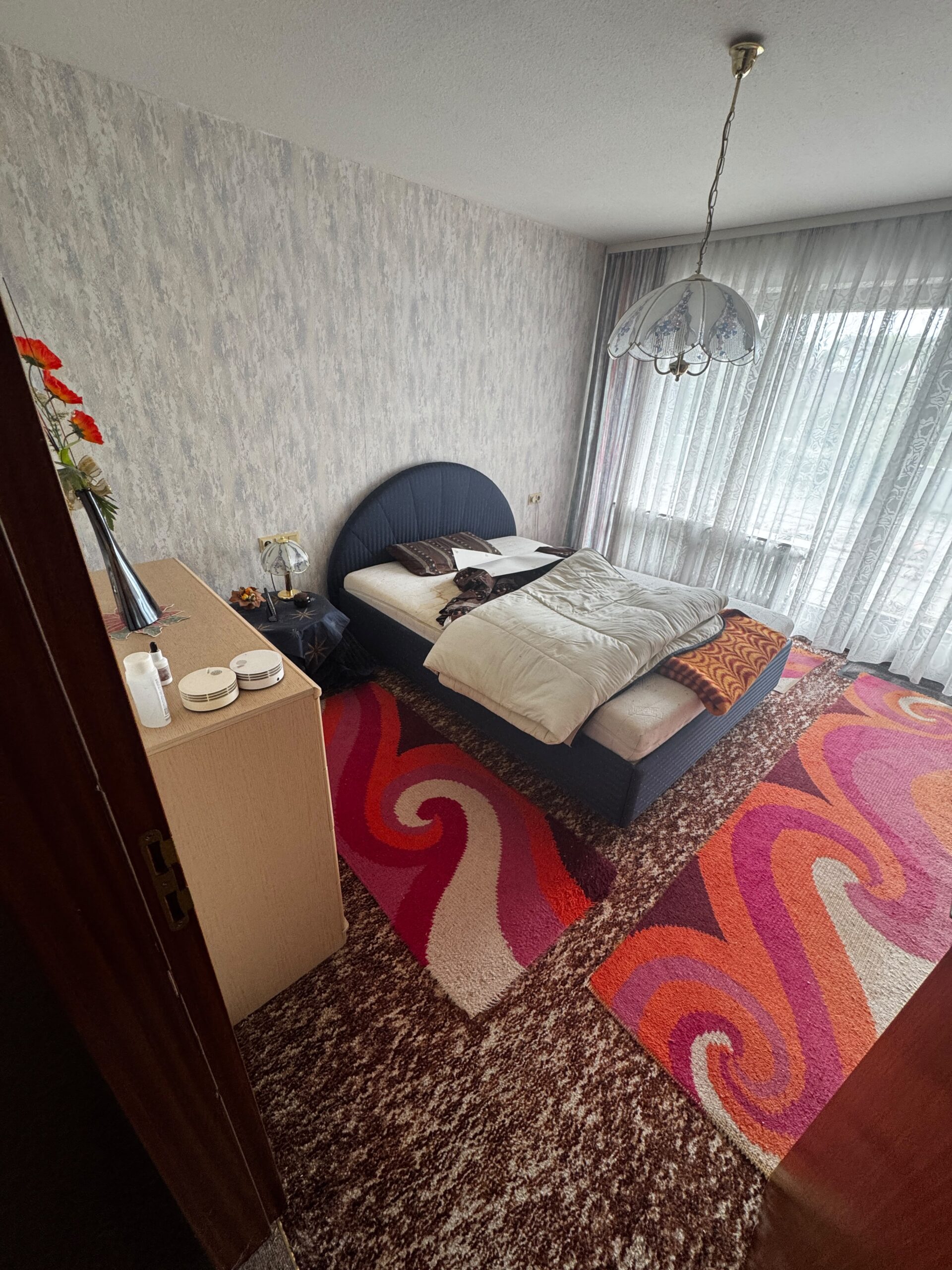 Vollgestelltes Zimmer mit Kartons, Taschen und Möbeln vor der Entrümpelung in Grevenbroich